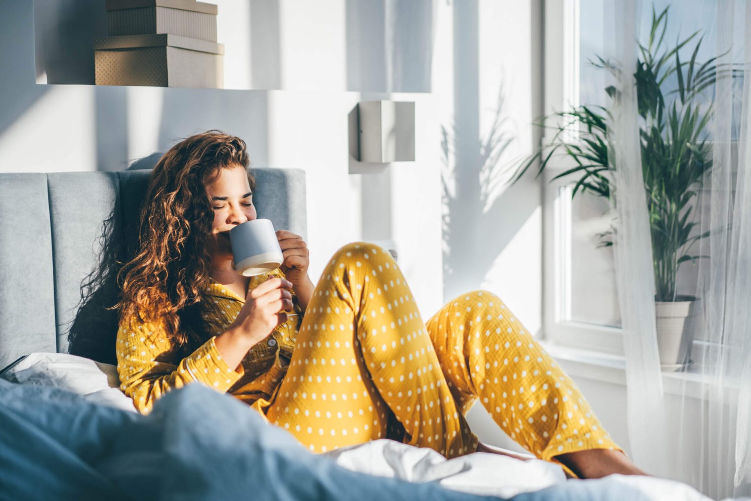 a person in bed sipping from a mug at apartmentss in pooler ga